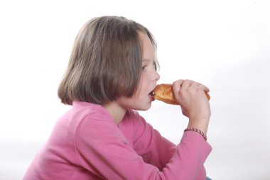 Genç bir kız çörek yiyor.