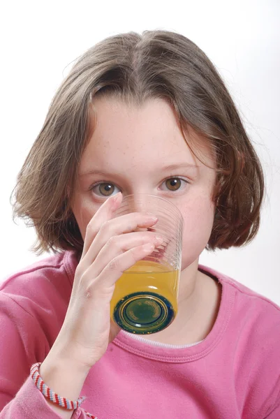 A young girl drinking orange juice glass — Stock Photo, Image