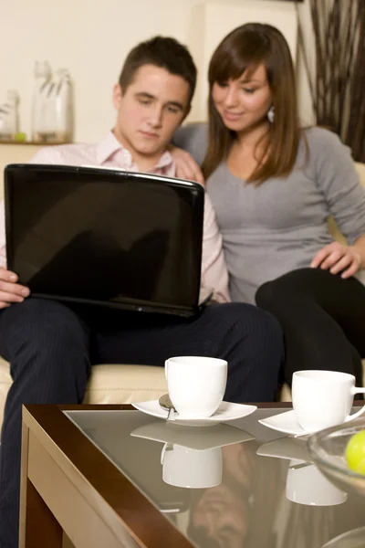 Coppia giovane con computer portatile e caffè. Focus sul caffè — Foto Stock