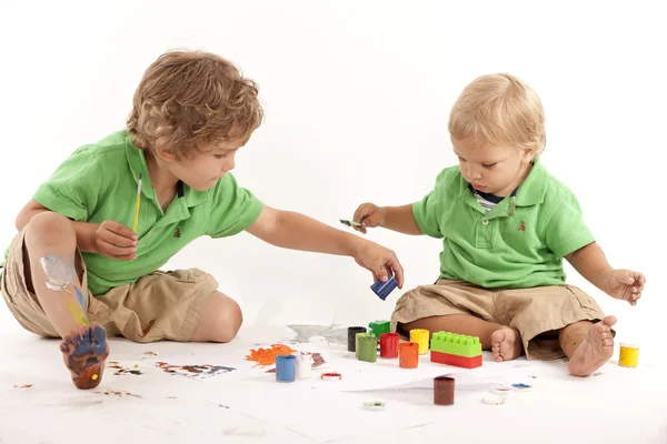 Siblings with paints and blocks — Stock Photo, Image