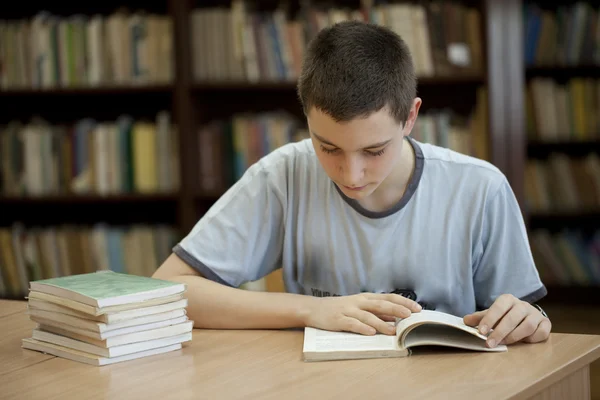 Молодой человек в библиотеке — стоковое фото
