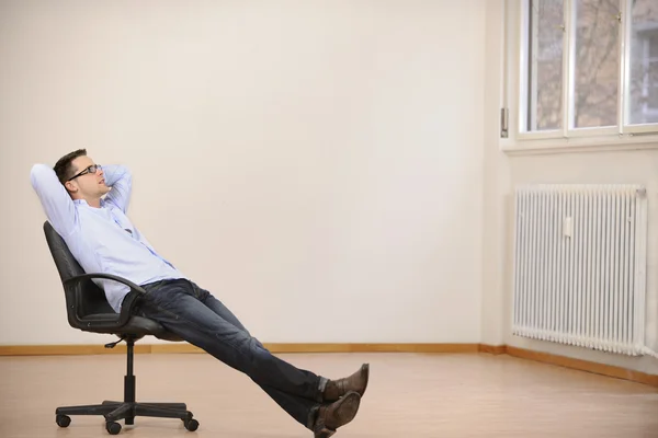 Geschäftsmann sitzt allein in neuem Büro — Stockfoto