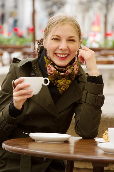 Красивая женщина пьет кофе в кафе на открытом воздухе — стоковое фото