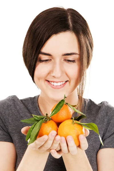 Jovem bela mulher segurando tangerinas frescas — Fotografia de Stock