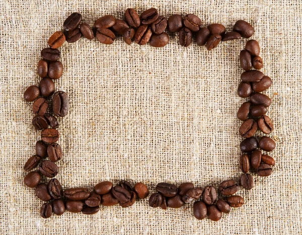 Кадр из кофейных зерен на мешковатой ткани — стоковое фото