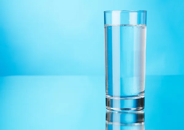 Bicchiere d'acqua su sfondo blu — Foto Stock