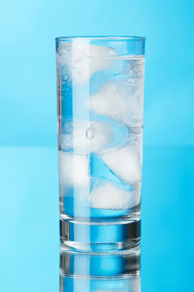 Стакан ледяной воды на синем фоне — стоковое фото