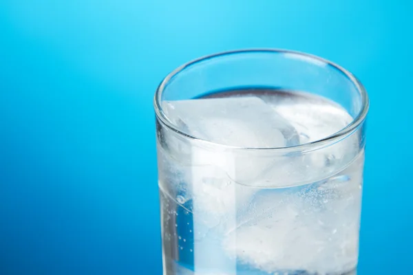 Ποτήρι νερό πάγο σε μπλε φόντο — Φωτογραφία Αρχείου