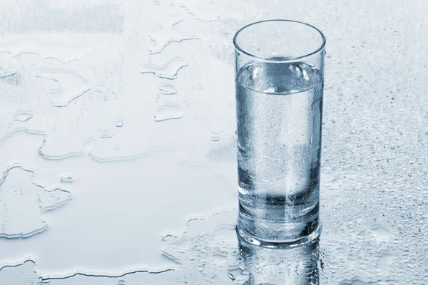 Glas vatten på blå bakgrund — Stockfoto