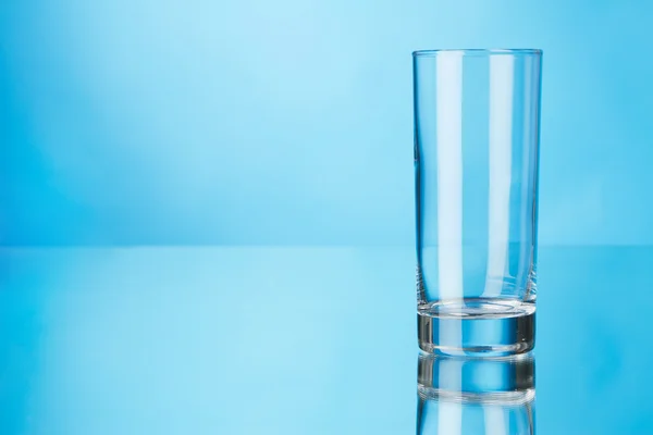 Leeres Glas auf blauem Hintergrund — Stockfoto