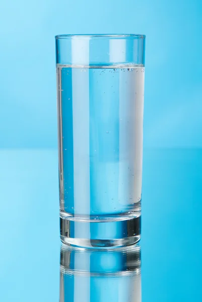 Vaso de agua sobre fondo azul — Foto de Stock