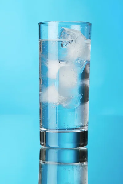 Glas Eiswasser auf blauem Hintergrund — Stockfoto