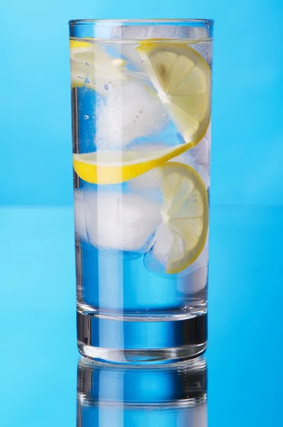 杯柠檬冰水蓝色的背景上 — 图库照片