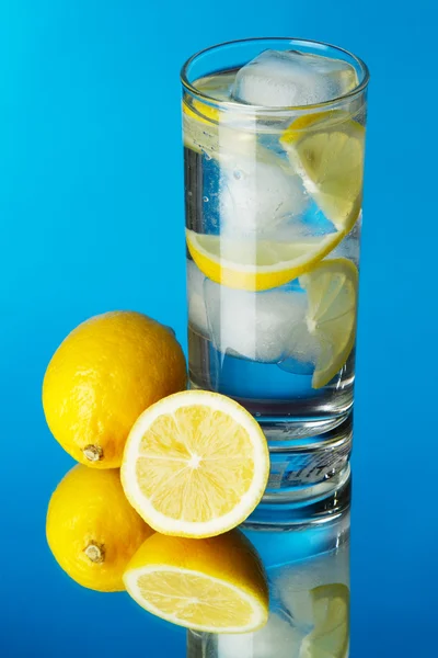 Glas med citron isvatten på blå bakgrund — Stockfoto