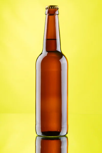Caneca de cerveja e garrafas no fundo amarelo — Fotografia de Stock