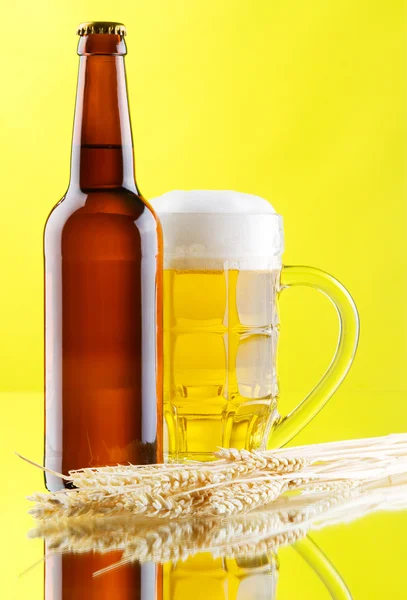 Ποτήρια μπίρας και μπουκάλια σε κίτρινο φόντο — Φωτογραφία Αρχείου