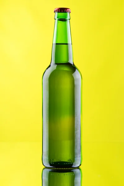 Ποτήρια μπίρας και μπουκάλι σε κίτρινο φόντο — Φωτογραφία Αρχείου