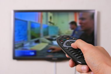 Remote control in man's hand and TV set clipart