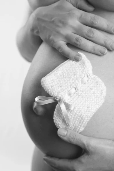 Беременная женщина и детские сапоги — стоковое фото