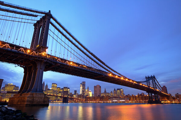 Manhattan Bridge with lower Manhattan skyline and Brooklyn Bridge at dusk in New York City