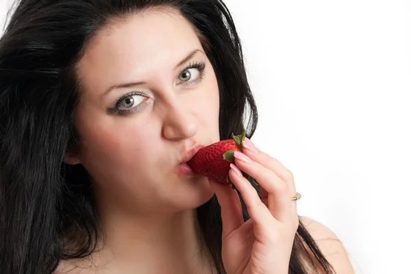 stock image The girl takes a bite of a strawberry