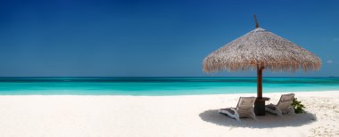Beach Chairs and Umbrella on a beautiful island, panoramic view with much c