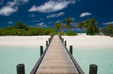Jetty leading to a tropical island clipart