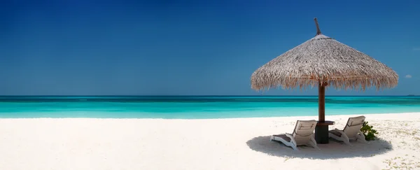 Ξαπλώστρες και ομπρέλα σε ένα πανέμορφο νησί, πανοραμική θέα, με πολύ c Εικόνα Αρχείου