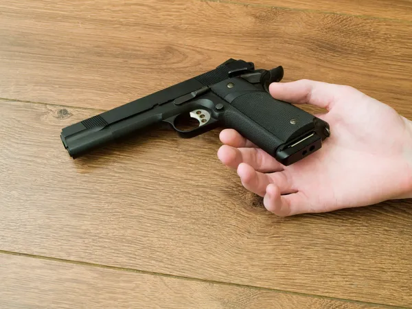 Black Pistol Gun in Dead Hand — Stock Photo, Image