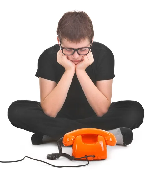 Rapaz triste está à espera de um telefonema esperado. — Fotografia de Stock