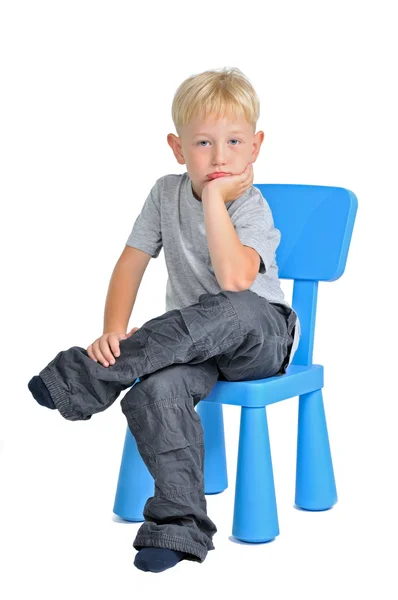 Trauriger Junge sitzt auf einem Stuhl — Stockfoto
