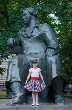 Little girl and the statue of russian poet Ivan Krylov, Moscow clipart