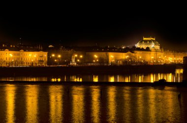 The Prague National Theater and the Vlava river at night clipart