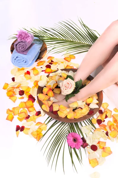 Женские ноги в чаше спа-салон для ног с цветами, лепестками и полотенцами изолированы на — стоковое фото