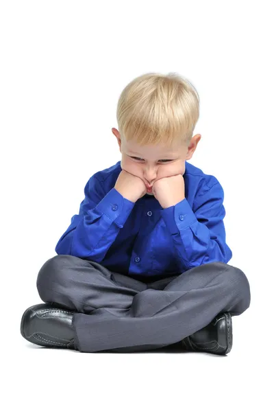 Smutny chłopiec siedzi w lotosu stanowią komplet — Zdjęcie stockowe