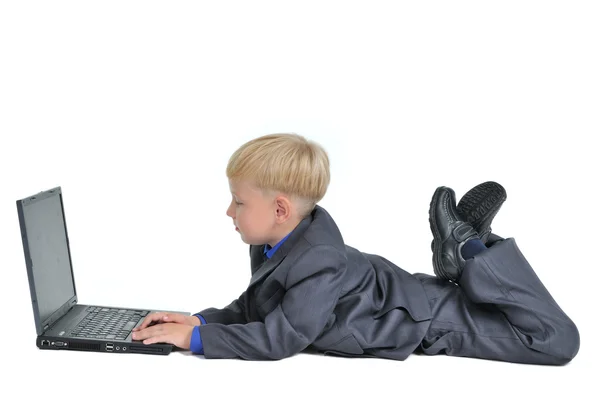 Mały chłopiec ubrany garnitur działa na laptopie — Zdjęcie stockowe