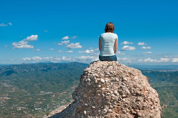 Girl on a cliff looking at view — Stock fotografie