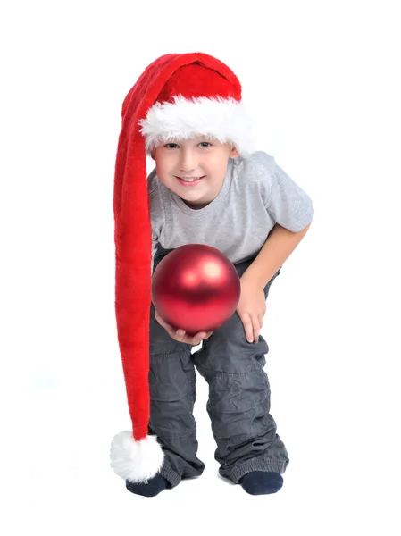 Chłopiec z santa hat i czerwone ozdoby świąteczne — Zdjęcie stockowe