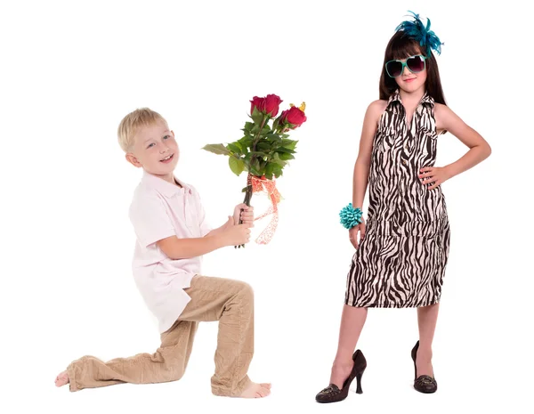 Smiling boy presenting bunch of red roses to his girlfriend — Stock Photo, Image