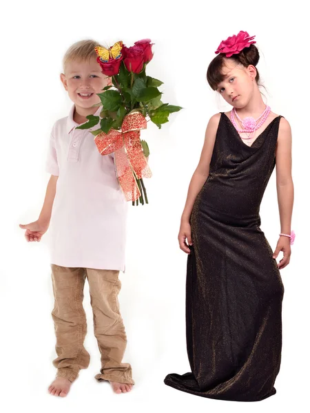 Sorrindo menino apresentando um monte de flores para menina elegante — Fotografia de Stock