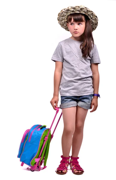 Маленька дівчинка в пальмовій шапці з дорожньою сумкою — стокове фото