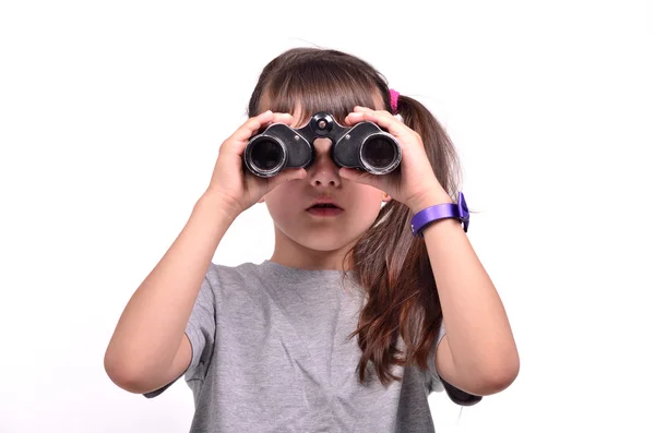 Morena menina olhando através de binóculos isolados — Fotografia de Stock