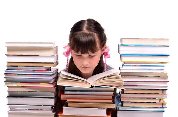 Poco gire leer un libro sentado entre pilas de libros — Foto de Stock