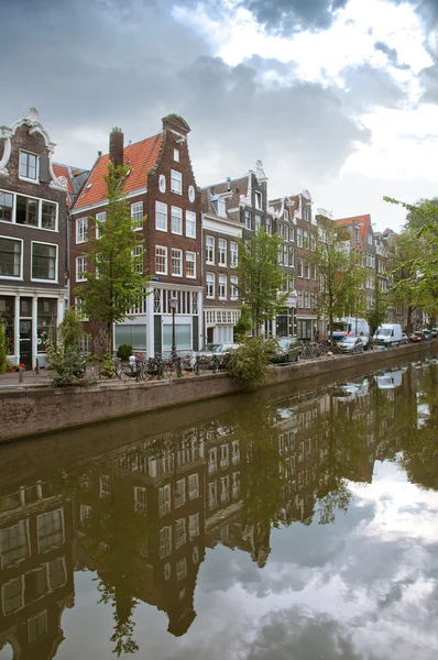 Amsterdamské kanály a typické domy s odrazy vody — Stock fotografie