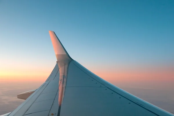 Αεριωθούμενο αεροπλάνο στο ηλιοβασίλεμα - πτέρυγα που φωτίζεται από την Ανατολή του ηλίου — Φωτογραφία Αρχείου