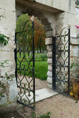 Romantic fence gate leading to rose garden clipart