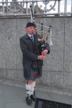Scottish Bagpiper in plaid and kilt with the Bagpipe, Princess Street, Edin clipart