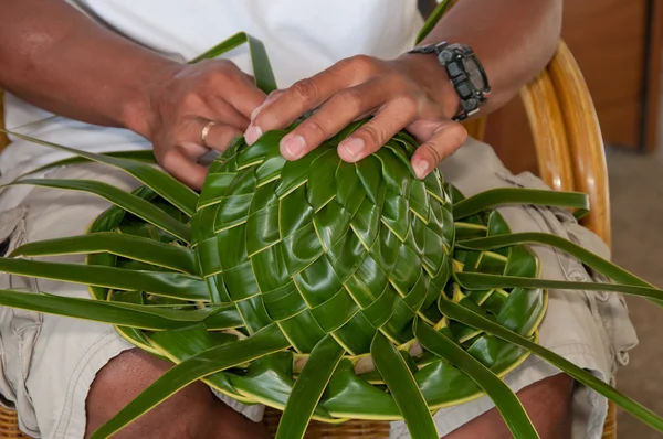 Woman making sunhat of palm leaves — Stock Photo, Image