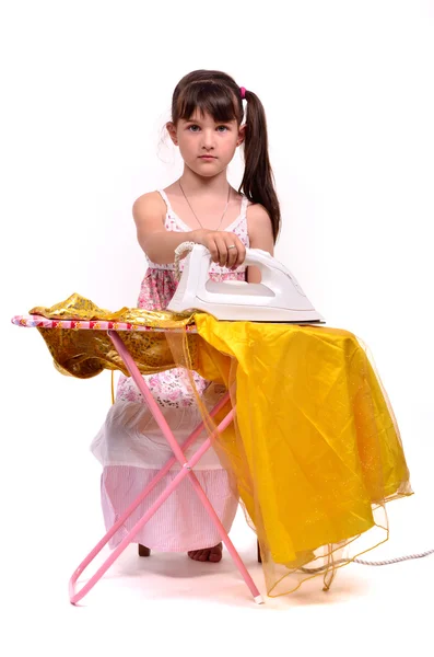 Farliga hushållsarbete - liten flicka Strykningsservice hennes klänning — Stockfoto