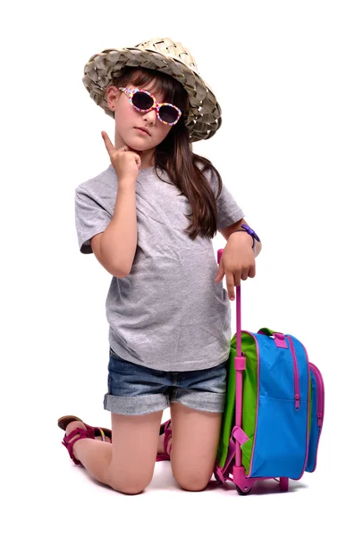 Little girl with travel bag with her finger up — Stock Photo, Image